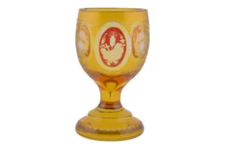 Gelber Glasbecher mit Motivschnitzereien